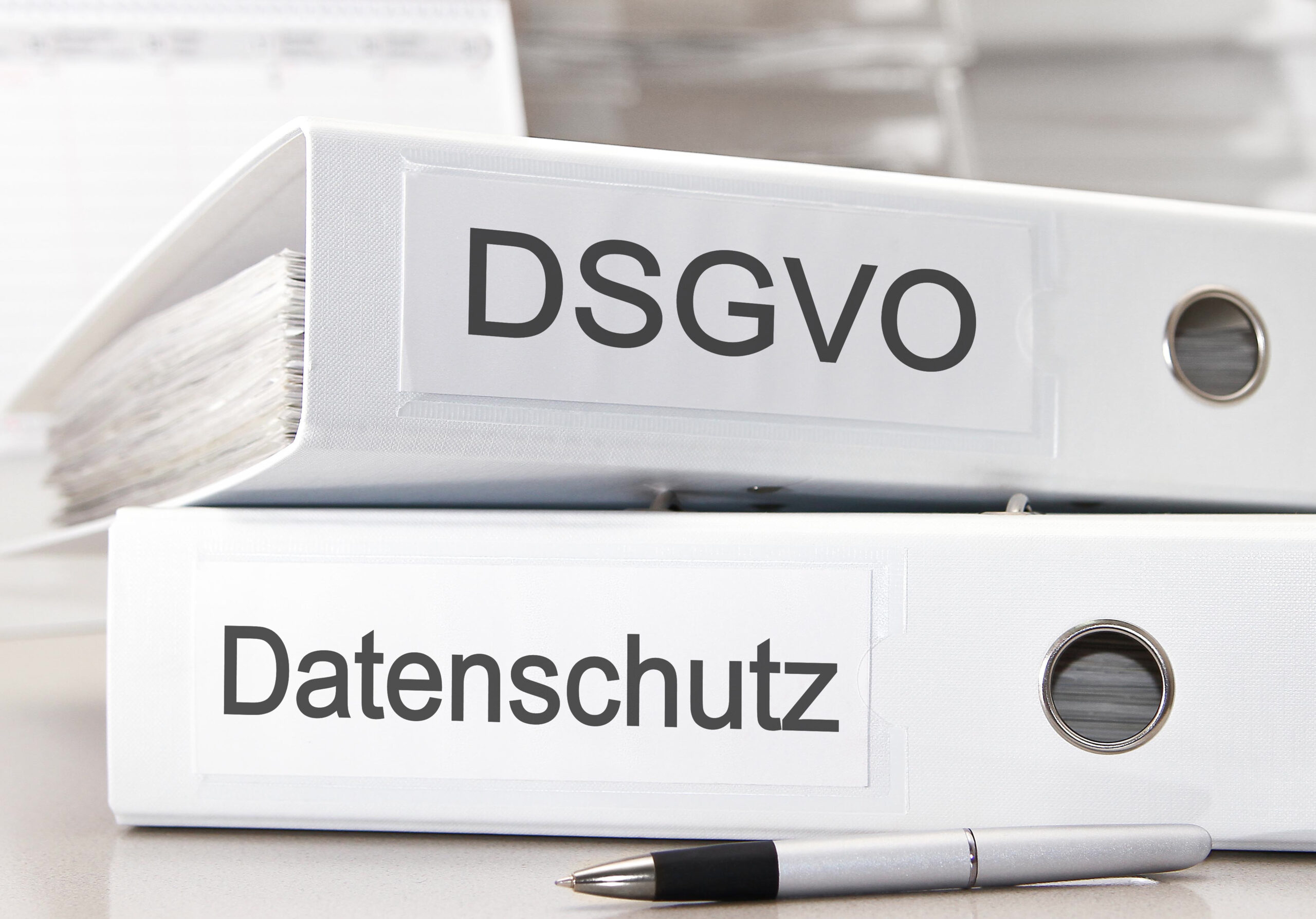 DSGVO und Datenschutz liegen als Ordner auf dem Bürotisch